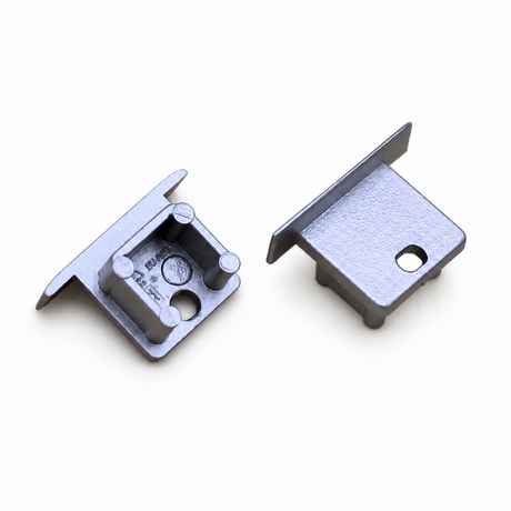 Two grey metallic End Cap for Smart-In10 Profile pieces, one shown from the underside and one from the top, each with a mounting hole.