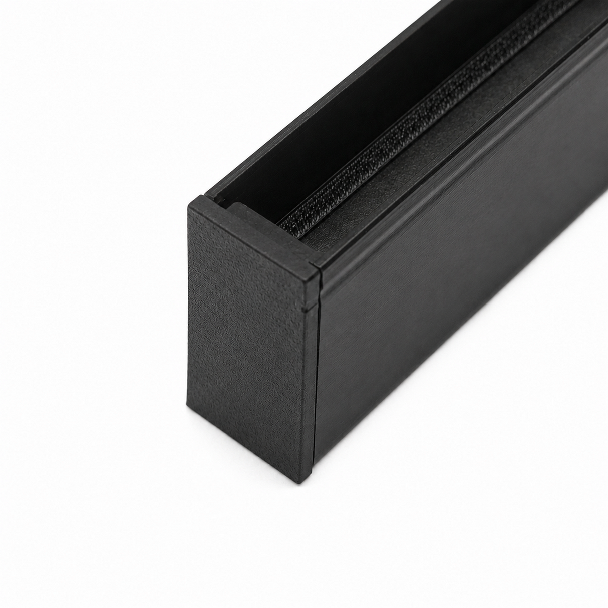 Close-up of a black Plastic End Cap for Hannover Profile, 3D printed with a textured finish. The rectangular cap is partially open, revealing its dark interior, and is set against a white background.