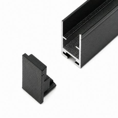 A black Hannover Profile metal channel with a hollow, grooved cross-section is shown on a white background alongside the Plastic End Cap for Hannover Profile in matching black plastic.
