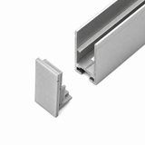 A silver metal rectangular Hannover Profile channel with an open groove is shown next to a Plastic End Cap for Hannover Profile, both placed on a white background. The End Cap appears designed to fit into the open end of the channel.