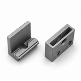 Two machined metal parts: one is the Wall Mounting Bracket for Hannover Profile, an L-shaped bracket with a groove, and the other is a rectangular block with three circular holes and one rectangular opening. Both feature a metallic, polished finish.