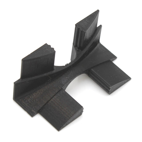 A black, angular Plastic Corner Connector for Alu-Flat Profile with multiple ridges and rectangular extensions, 3D printed in plastic, lies on a white background. This specialized mechanical component serves as a corner connector.