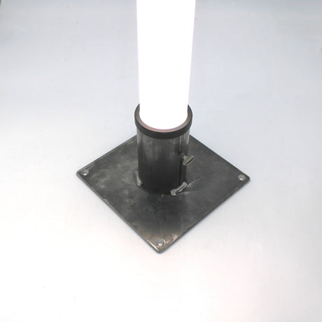 The Steel Base for 2.56" Round Profiles is a sturdy steel plate with four bolt holes, designed to mount a round diffuser tube vertically as a secure floor stand on flat surfaces.