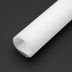 A Round Methacrylate LED Diffuser Tube ~ Model Oslo, featuring a cylindrical frosted white design with an open end, is placed diagonally on a plain black background.