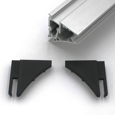 A close-up of the End Cap for Pula P10 Profile with two black plastic corner connectors and an aluminum extrusion, all on a white surface—ideal for finishing the Pula P10 edge-lit shelf profile.