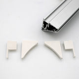 A silver Pula P10 edge-lit shelf profile extrusion bar with a hollow design is shown above four white End Caps for the Pula P10 Profile, each made of PETG plastic in different shapes, all on a white background.