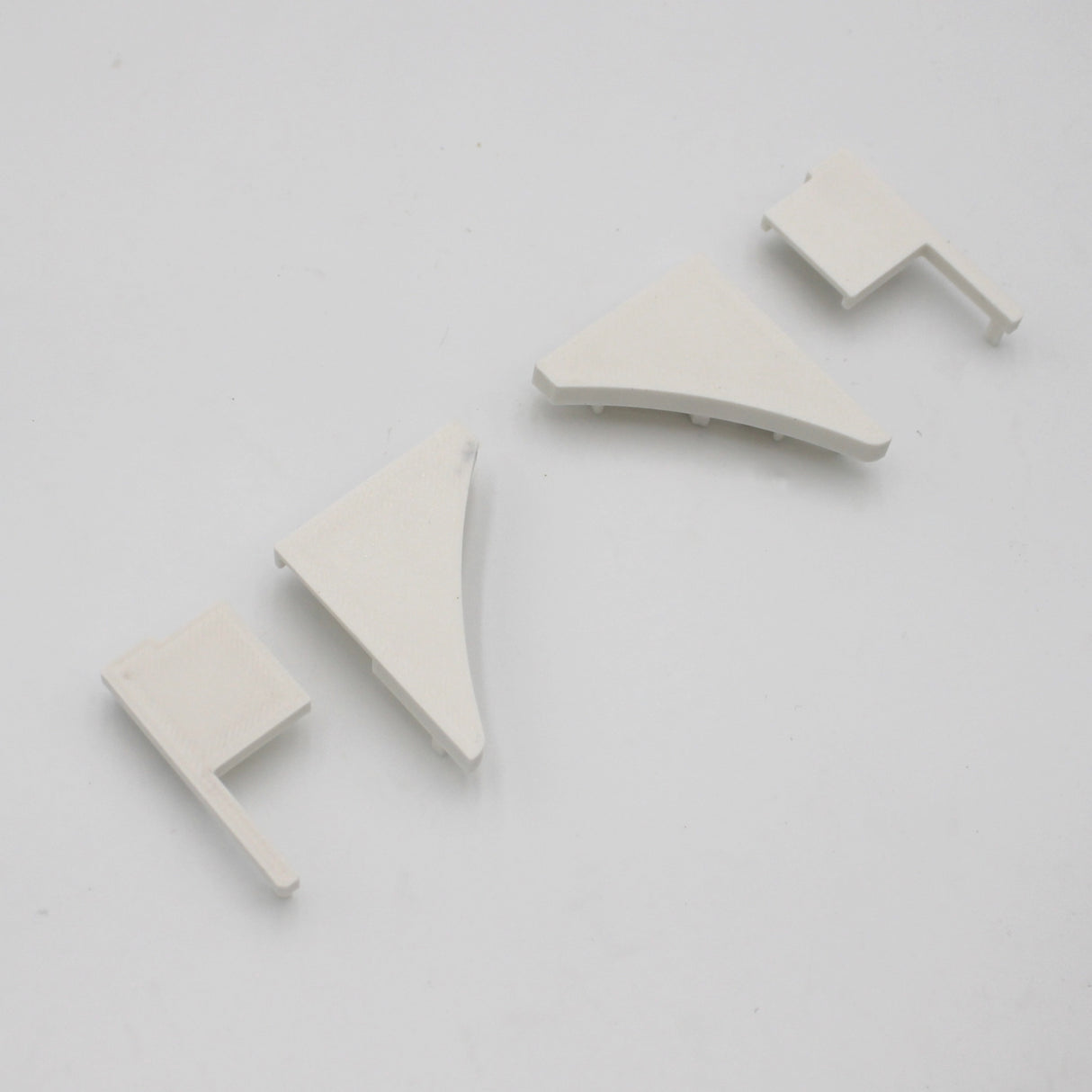 Four PETG end caps for the Pula P10 Profile, in assorted triangular and rectangular shapes, are displayed on a white surface.