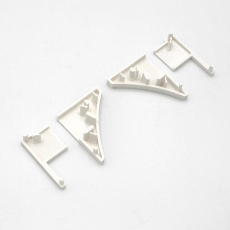 Four small, white End Caps for Pula P10 Profile, each with various raised notches and tabs, displayed in a row on a white background.