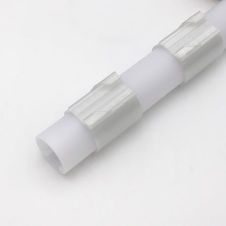 A Drop Ceiling T-Bar Clip for 1.5 Round Profiles, made of white plastic with two textured grip sections, is shown diagonally on a plain white surface.