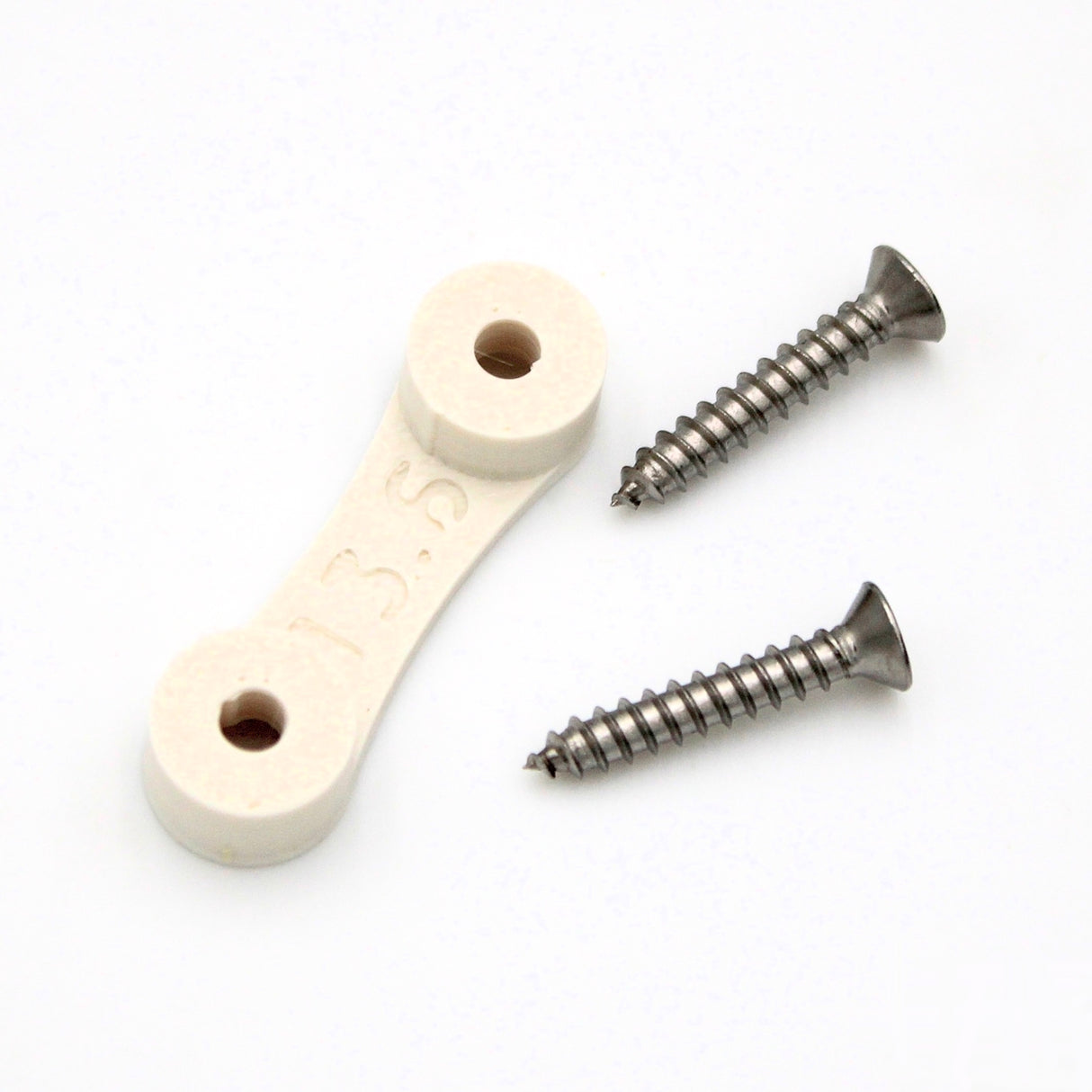 The LED Strip Saddle, a white plastic surface mount bracket with two holes and "13.5" embossed, is shown next to two silver metal screws—ideal for securing waterproof LED strips—on a white background.