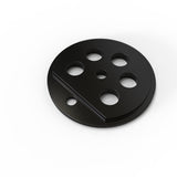 A round, flat, black Aluminum End Cap for Sierra38 Profile with six circular holes of varying sizes and a raised diagonal ridge sits on a white background.