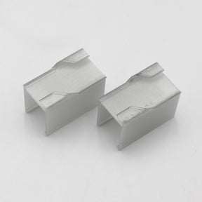 Two rectangular, silver Drop Ceiling T-Bar Linea20 Clips with open sides and angled top notches, designed as accessories for Linea20 profile mounting, are shown on a plain white background.