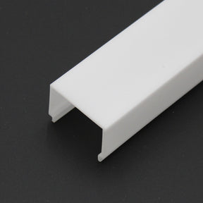 The LED Channel Cover ~ E9 Click is a white, rectangular, U-shaped PMMA channel resting at an angle on a black surface, with open ends visible—perfect as a diffuser or channel for LED lighting projects.