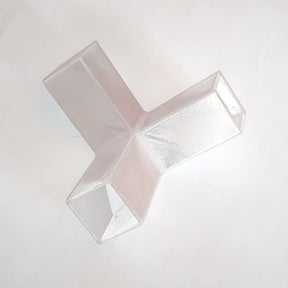 A Translucent Elbow with Crossing for Visby Profile, featuring three rectangular prongs extending from a central junction in a Y or T shape, is placed on a white background.