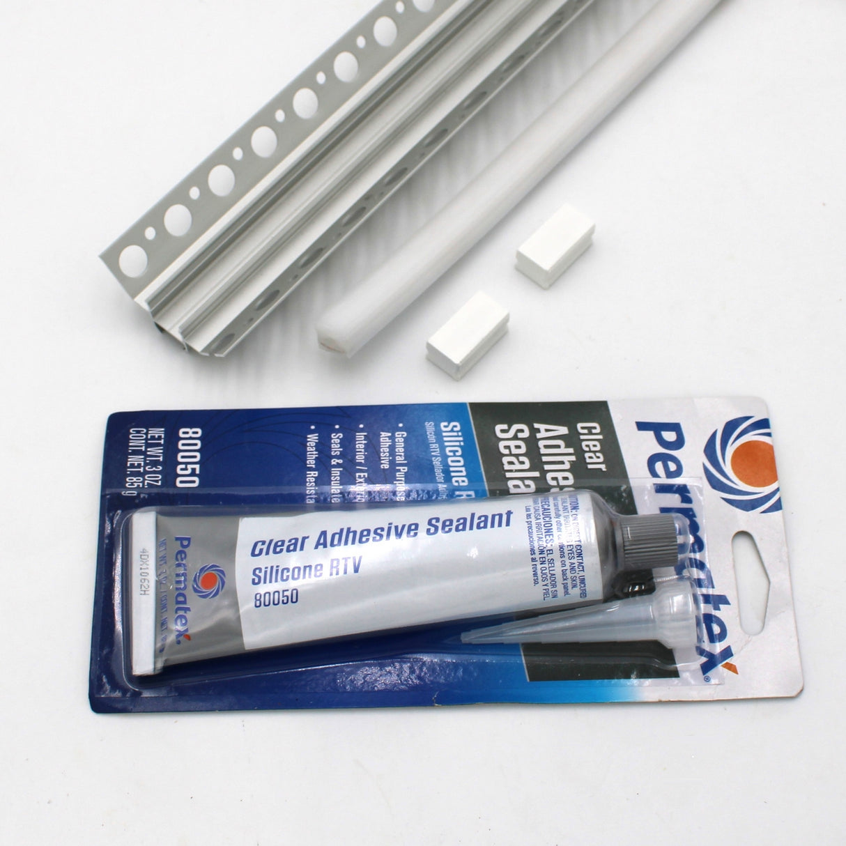 A White LED Tile Light Strip Kit for Inside Corners (24V) ~ Nicho Series is shown in its packaging with mounting accessories—ideal for easy, waterproof LED installation and securing parts on tiled surfaces.