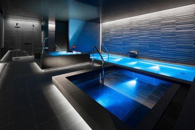 Luxurious spa pool area illuminated with RGBWW LED strips for a relaxing blue ambiance and accent wall lighting.