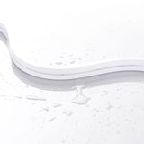 The White IP44/IP66 Neon Flexible LED Light Line (24V) ~ Flex Ultra Slim Series rests on a glossy surface with scattered water droplets, showcasing its minimal and clean design for architectural lighting applications.