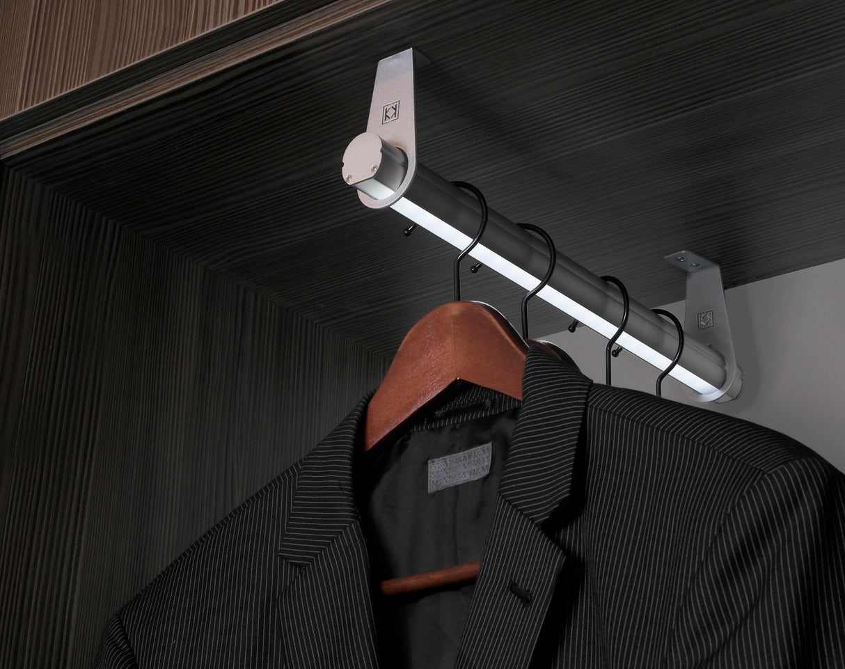 A black pinstripe suit jacket hangs on a wooden hanger beneath the 1.1" Oval Wardrobe Rail Lighting LED Channel ~ Model Oval20, featured in an elegant dark wood closet.