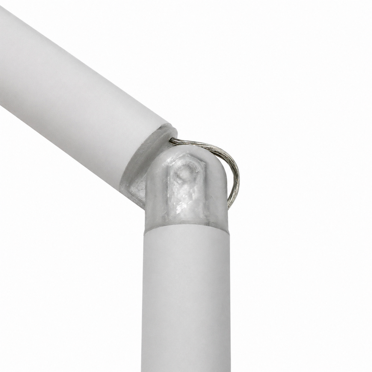 Two white cylindrical objects connected at an angle by a metal wire loop, against a plain white background—this elegant setup features the Hinge for Oslo Mini Profile, an adjustable lighting hinge designed for seamless integration within a diffuser tube system.