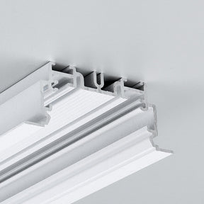Close-up of the 2" Recessed Easy-Mounting LED Strip Channel ~ Model Phil.v2 Recessed, shown with a white decorative ceiling molding featuring layered grooves, seamlessly installed in a light gray ceiling for smooth LED strip integration.