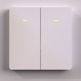 A close-up of the Casambi Wireless Battery-Operated 2-Button Wall Switch (Eulum SWC-CSB-2R-W), a modern white smart switch with yellow indicator lights on each button, mounted on a plain light-colored wall.