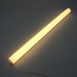 The 1.5" White Surface-mount LED Tube Lighting Fixture (24V) from the Sierra38 Series glows warmly on a dark surface with its power cord visible—perfect for easy, plug-and-play surface mounting.