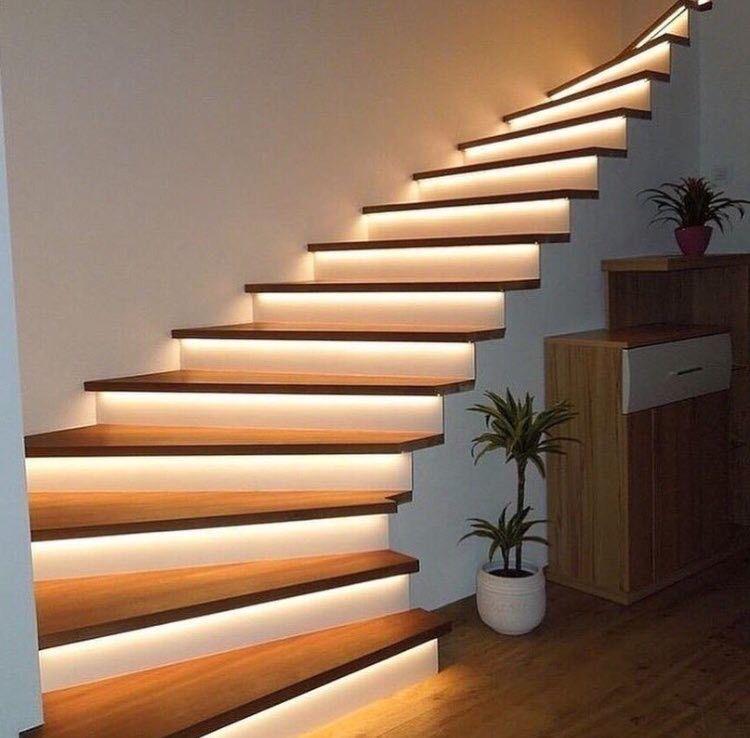 Sleek floating staircase with under-step RGBWW LED strip lights providing warm white safety lighting and design enhancement.