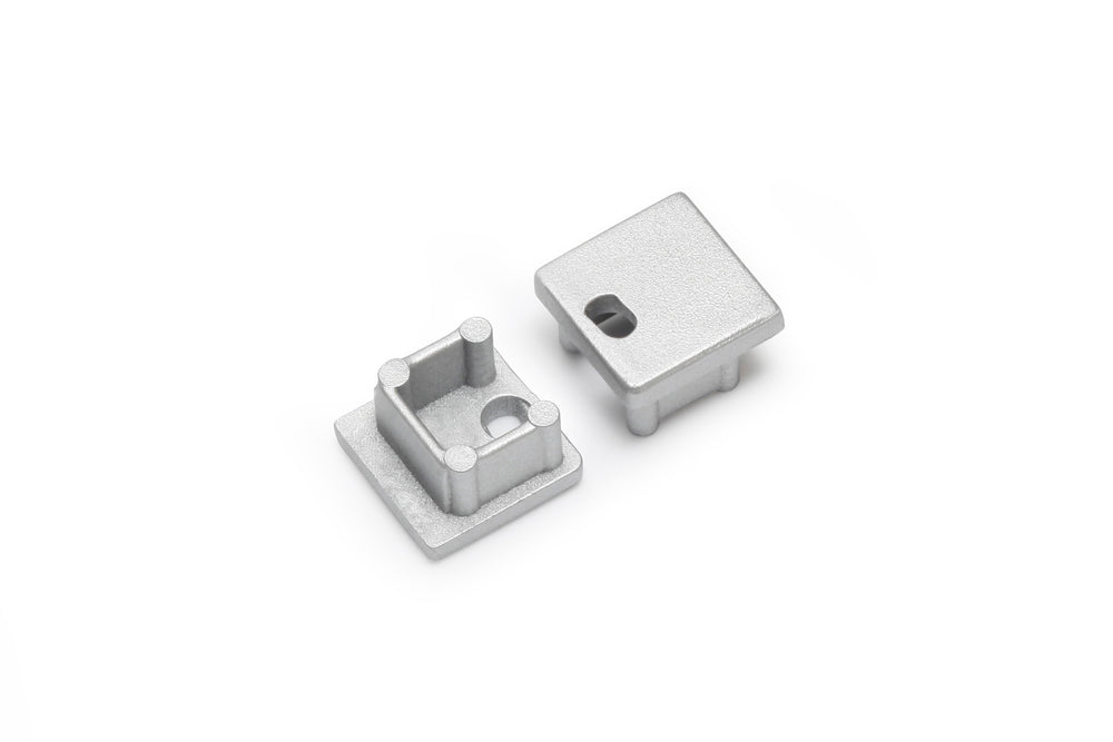The End Cap for Smart10 Profile set includes two small, square, silver-finished metallic caps—one with a hollow interior and posts, the other flat with a rectangular cutout—designed for lighting fixture installations.
