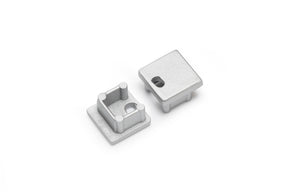 The End Cap for Smart10 Profile set includes two small, square, silver-finished metallic caps—one with a hollow interior and posts, the other flat with a rectangular cutout—designed for lighting fixture installations.