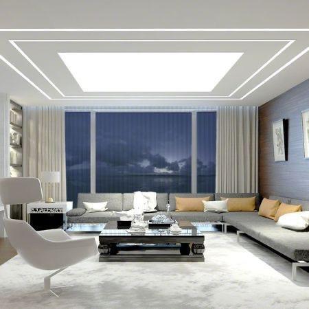 Stylish living room featuring cool white LED strip lights embedded in a recessed ceiling, creating soft ambient lighting across the space.