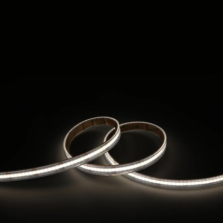 The RGB+CCT COB IP67 High CRI LED Strip (24V) from the EnoLED UniColor Series forms smooth curves on a deep black surface, emitting bright, even white light.