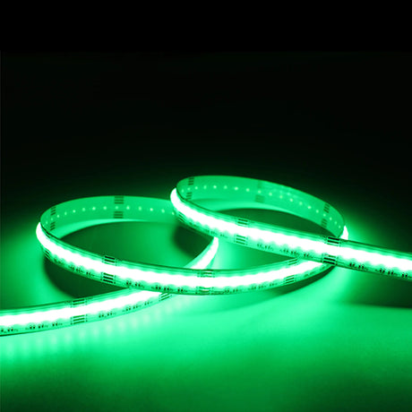 The EnoLED UniColor Series RGB+CCT COB IP20 High CRI LED Strip (24V) glows green in loose curves against a dark background, brightly illuminating the surface below.
