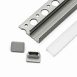 Tile Edge LED Strip Light Channel Kit ~ Model Uni-Tile12 180Deg shown: metal channel with circular holes, frosted plastic cover, and two gray end caps on a white surface—ideal for recessed lighting or tile edge LED installs.