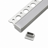The Tile Edge LED Strip Light Channel Kit (Model Uni-Tile12 180Deg), a silver tile trim with circular cutouts for LED installation, is shown beside a small rectangular plastic end cap on a white background.