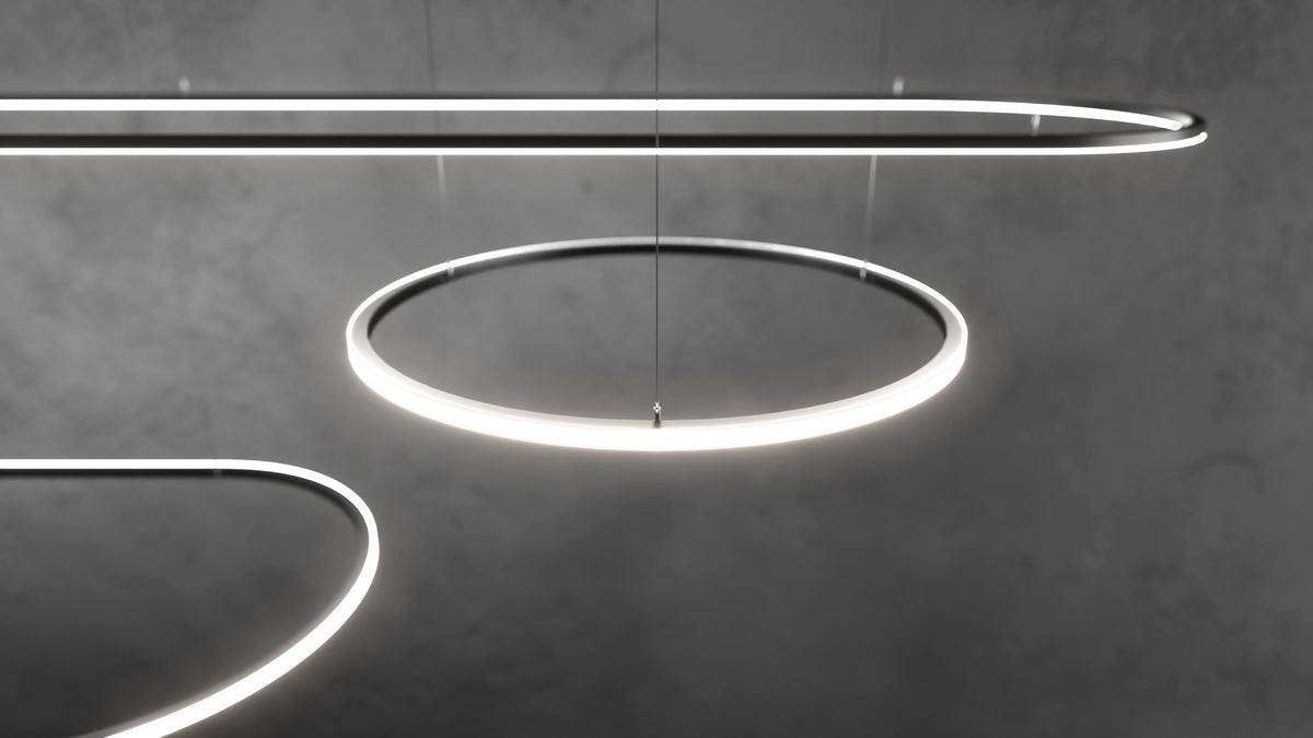 Three glowing, curved 0.51″ Suspended/Surface Mount Bendable LED Channel ~ Model Bend8 fixtures suspended by thin wires against a dark gray background.