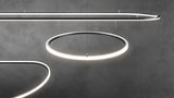 Three glowing, curved 0.51″ Suspended/Surface Mount Bendable LED Channel ~ Model Bend8 fixtures suspended by thin wires against a dark gray background.