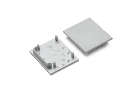 Two gray plastic End Caps for Vario30-03 Profile are shown side by side on a plain white background—one with pegs and markings facing up, the other as a flat cover. Perfect for lighting fixture installations.