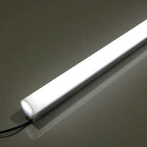 The White Border Contour Tube Light ~ Hi-Lite 30 Straight Section glows on a smooth, reflective surface, secured by polycarbonate clips with its power cord visible at one end.