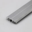 A close-up of the Flat Bar Aluminum Heatsink LED Profile ~ Model Yukon shows its grooved, ribbed silver strip on a white background, featuring a flat top and toothed underside for sealing or edging uses.