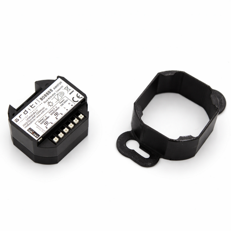 A black Casambi Smart Relay with terminal connectors and a removable, hexagonal PETG cover sits beside the Mounting Bracket for Casambi Smart Relay on a white background. Both devices show labels with text and symbols.