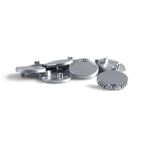 Seven silver End caps for Alu Round LED profile, each round and flat with raised tabs, notched edges, and a cable hole, are scattered on a white surface.