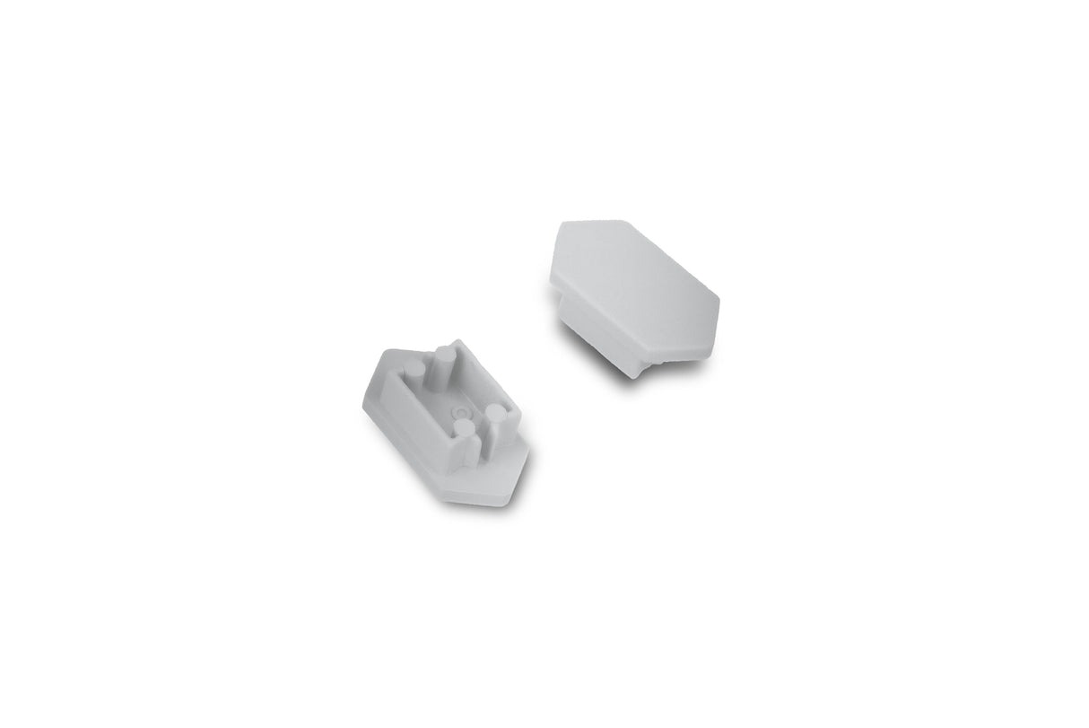 Two small white plastic C End Caps for Arc12 Duo Profile lighting fixture—each with angled sides—are shown on a plain white background; one end cap is facing up to display two pegs and a slot, while the other is facing down.