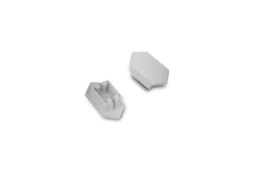 Two small white plastic C End Caps for Arc12 Duo Profile lighting fixture—each with angled sides—are shown on a plain white background; one end cap is facing up to display two pegs and a slot, while the other is facing down.