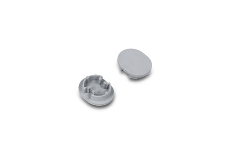 Two small, gray, oval plastic D End Caps for the Arc12 Duo Profile lighting fixture are shown; one end cap is positioned with the interior side facing up to reveal small ridges, while the other displays its smooth exterior surface. The items are set against a white background.