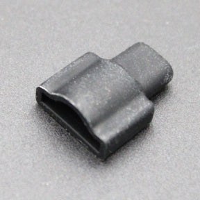 A small, black, rectangular Endcap for Optimum Black Neon Max with a curved top and an open end rests on a smooth, gray surface.