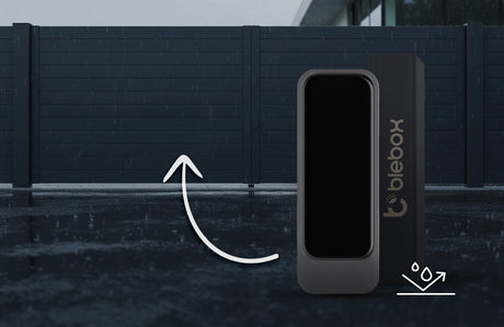 A Miniature Wi-Fi Smart Open/Close Sensor called openSensor by Blebox is displayed before a modern, closed sliding gate on a rainy day, with a white arrow indicating its function as a convenient smart home gate control.