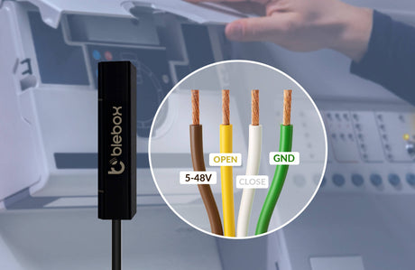A close-up of the openSensor by Blebox Wi-Fi Smart Open/Close Sensor shows four labeled wires—brown (5-48V), yellow (OPEN), white (CLOSE), green (GND)—against a blurred background with hands working on a control panel.