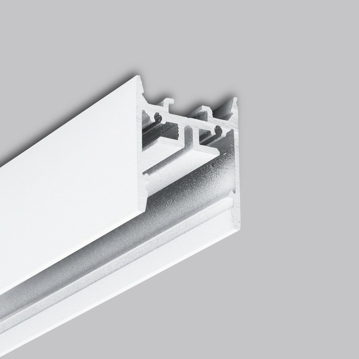A close-up of the 1″ Suspended/Surface Mount LED Channel ~ Model Pixy20-01 showcases its modern, minimalistic white metal track system against a plain gray background; the sleek aluminum structure is ideal for versatile and stylish lighting solutions.
