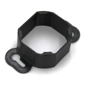 The Mounting Bracket for Casambi Smart Relay is a black, octagonal PETG bracket with two flat, rounded tabs featuring keyhole slots for secure mounting to surfaces. Ideal for use with the Casambi Smart Relay.