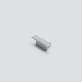 A single light gray Cut & Connect End Cap for Berlin Profile, resembling a LEGO piece, sits centered on a plain white background. Its sloped design and smooth top evoke the clean finish of an IP65 seal.